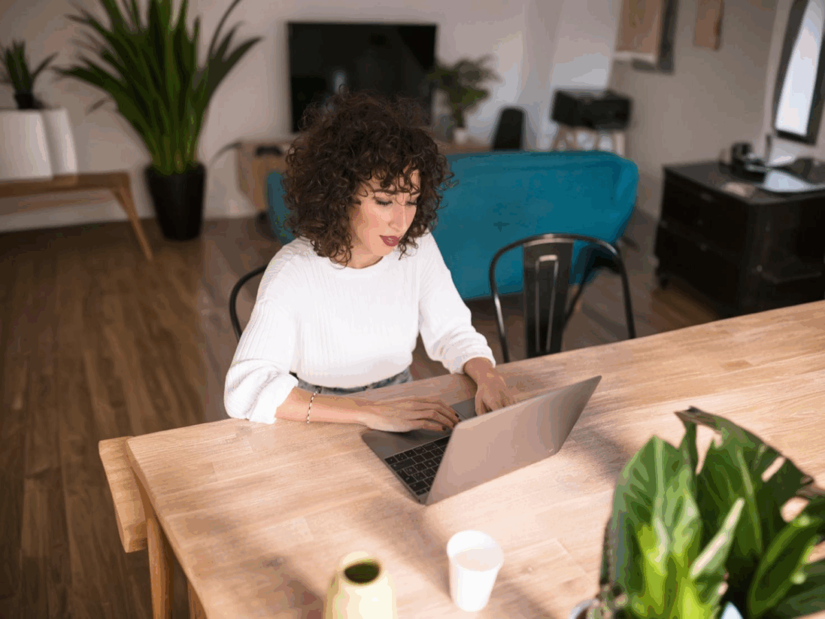 A woman sitting at a desk using a laptop computer.